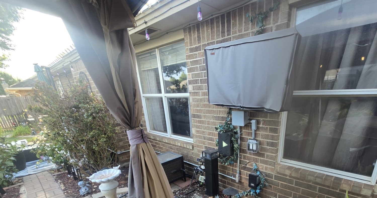 Completed outdoor electrical conduit and weatherproof receptacle installation on a brick exterior wall